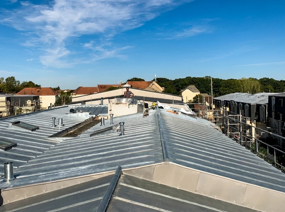 Couverture métallique en zinc à joints debout en cours de réalisation, vue aérienne depuis la toiture