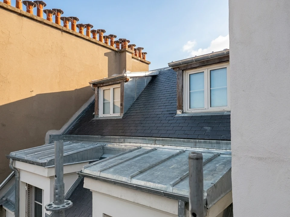 Chantier de toiture en extérieur, vue en plongée depuis un échafaudage tubulaire métallique rouge